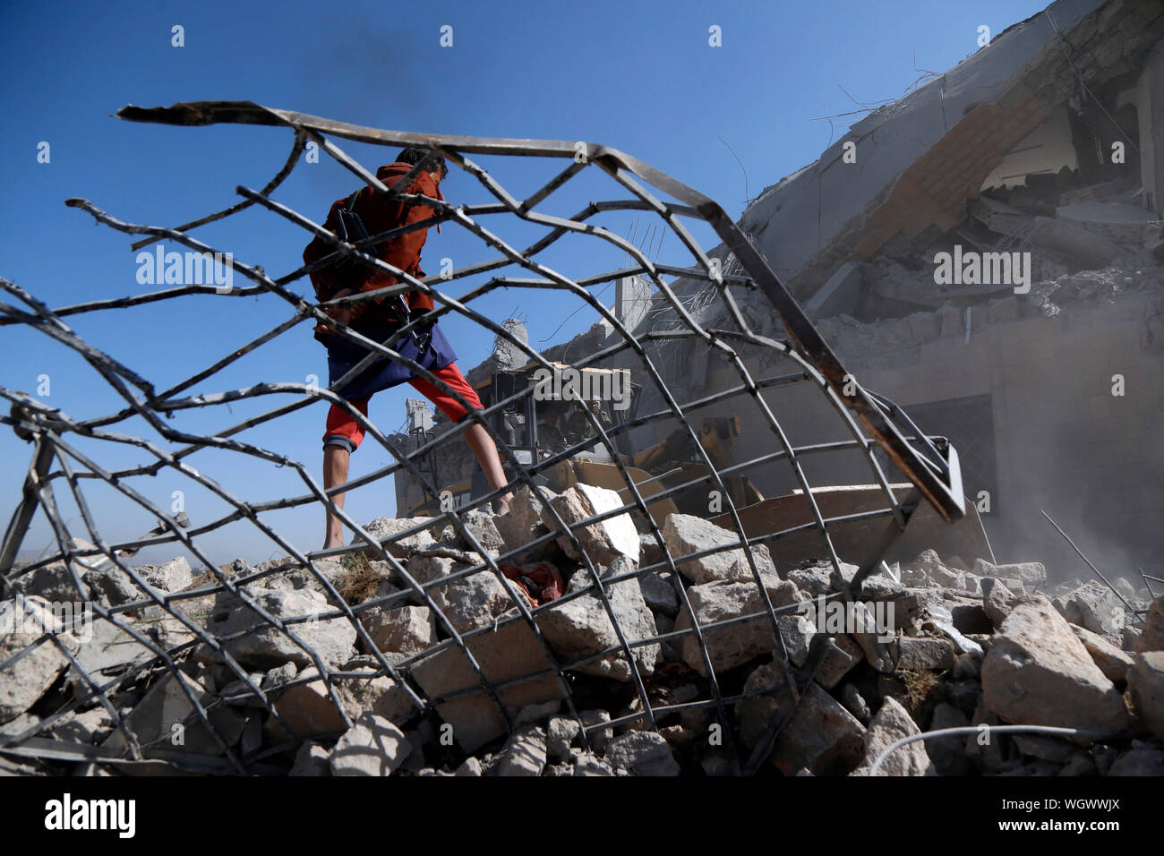 (190902) -- BEIJING, Sept. 2, 2019 (Xinhua) -- A man stands on the rubble of a prison in Dhamar Province, Yemen, Spet. 1, 2019. At least 50 prisoners of war were killed when the Saudi-led coalition launched a series of airstrikes overnight on a prison in Yemen's central province of Dhamar, the Houthi-controlled health ministry said in a statement early Sunday morning. (Photo by Mohammed Mohammed/Xinhua) Stock Photo