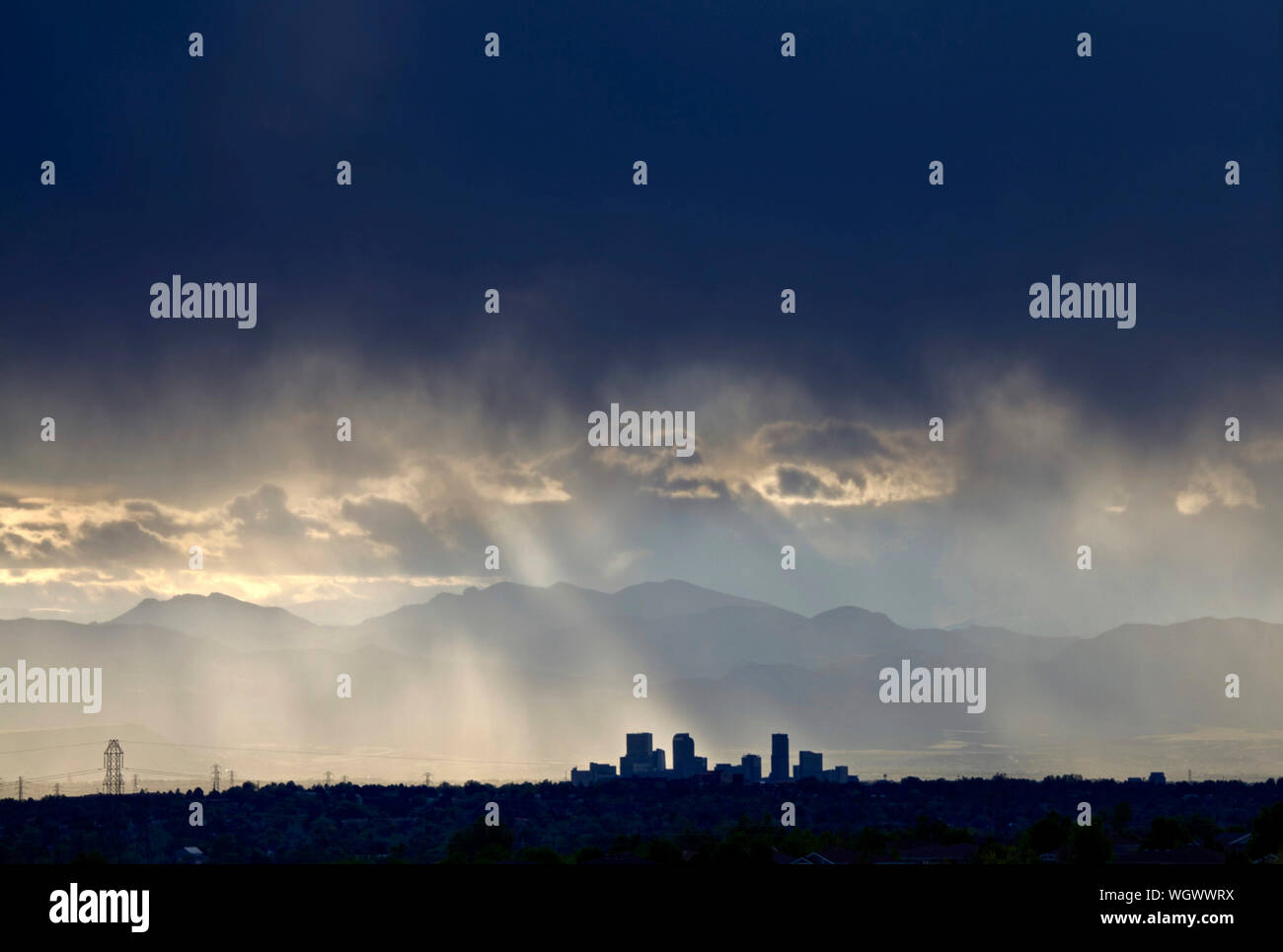 Denver Colorado's skyline facing west with the front range mountains in the background during a rain shower. Stock Photo