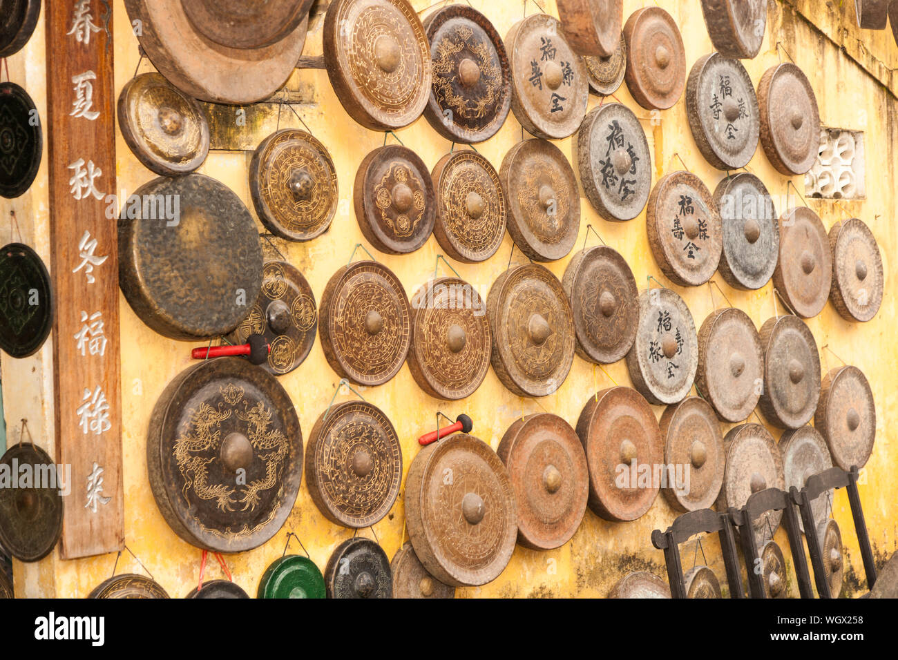 Sale of Gongs hanging on outside of shop for sale, Hoi An, Vietnam Stock Photo