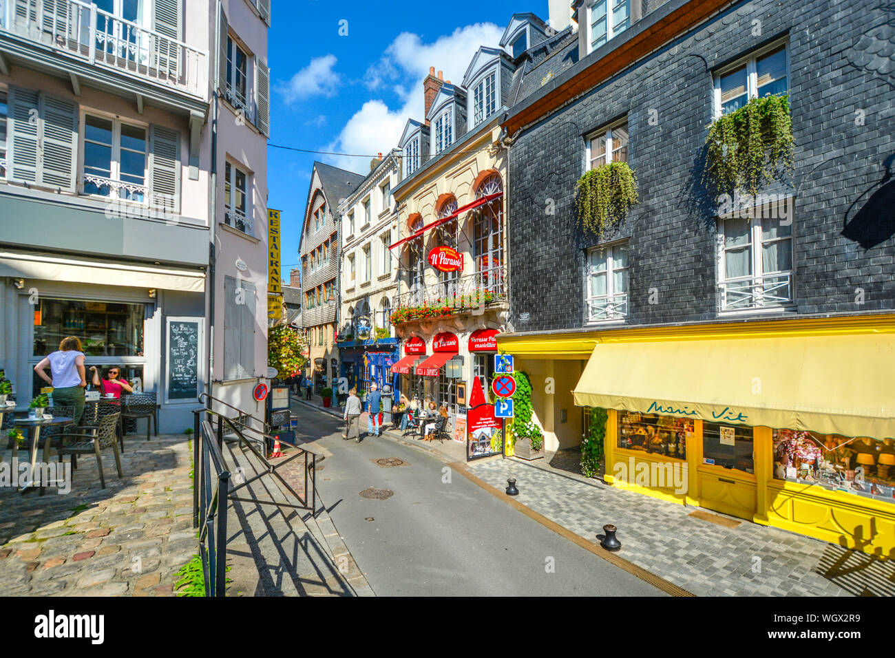 Tourists enjoy the sidewalk cafes and colorful shops in the coastal