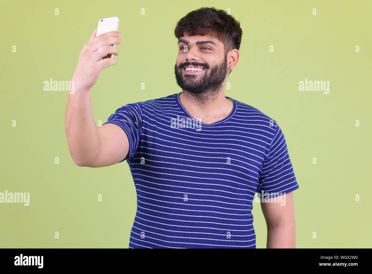 Happy young overweight bearded Indian man taking selfie Stock Photo - Alamy