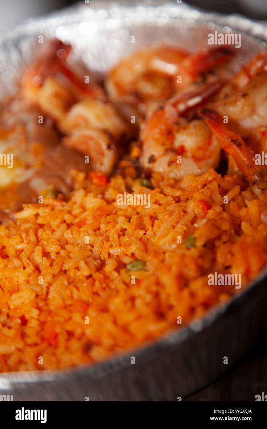Grilled shrimp, fried rice, and refried beans in a baking tin Stock