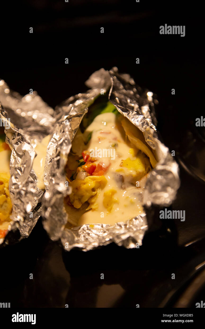 Avocado and egg burritos in corn tortillas, topped with creamy queso