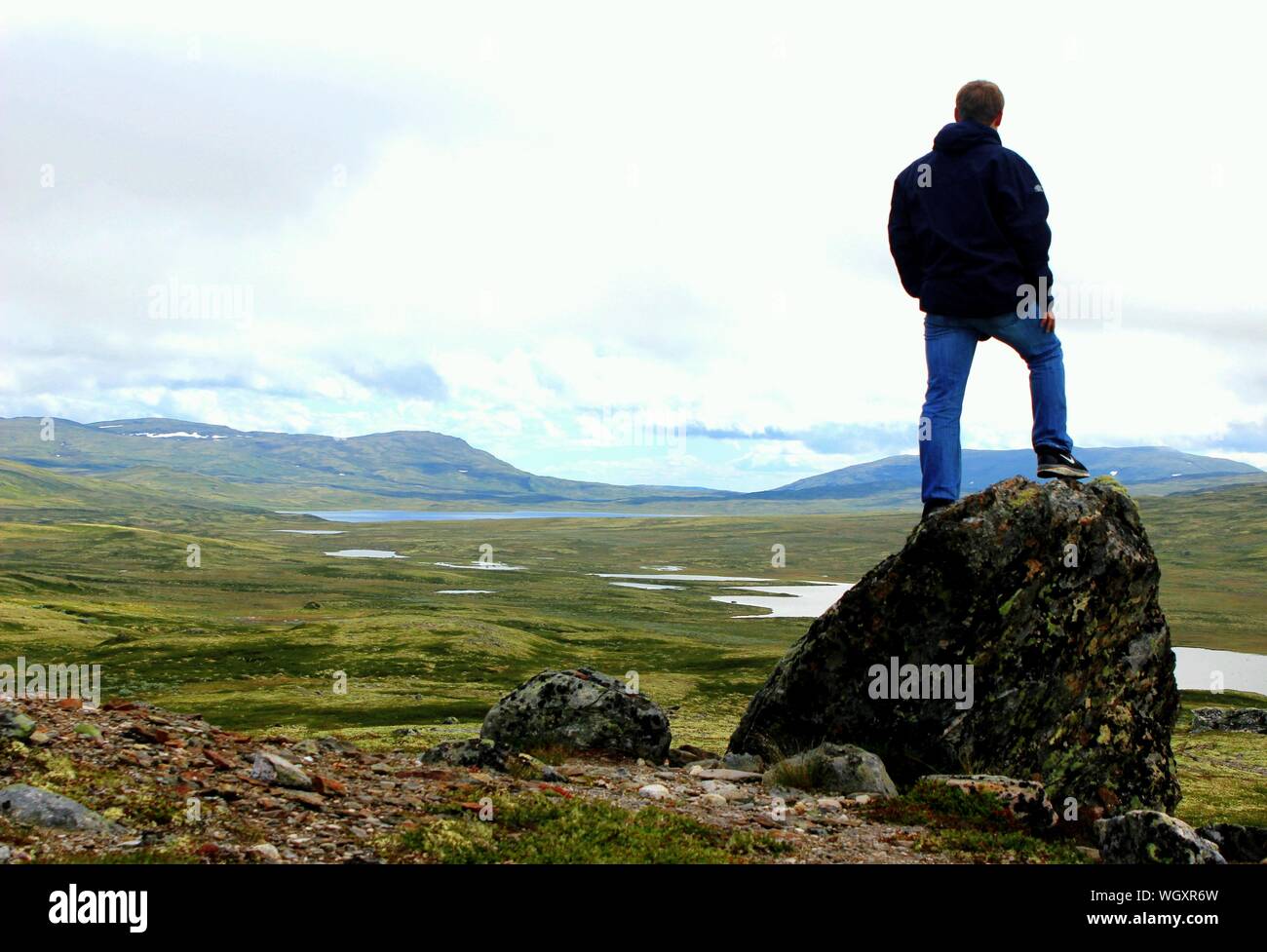 Full Length Rear View Of Man Standing On Rock Watching Landscape Stock Photo