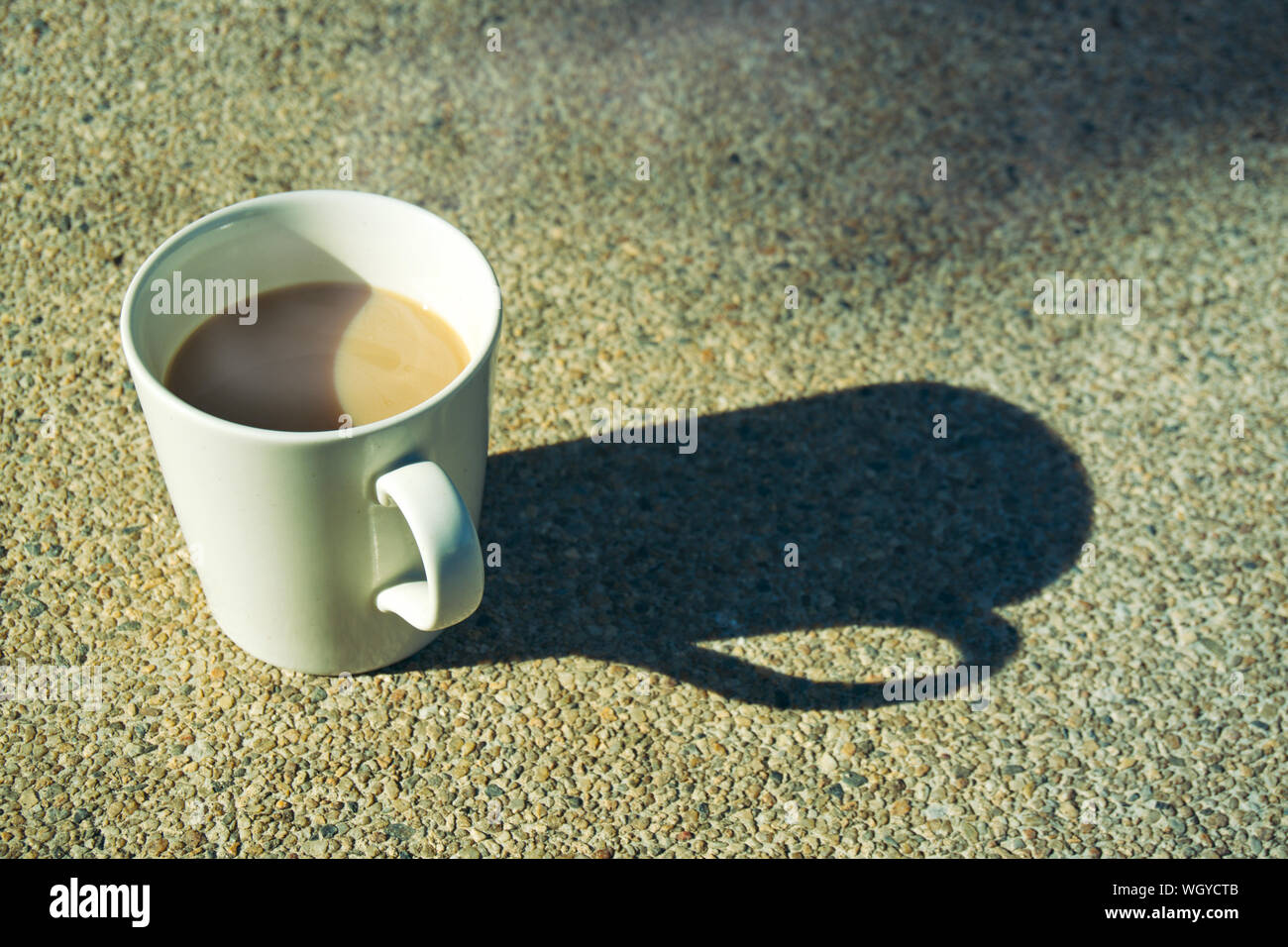 In the morning, a coffee cup on the ground with soft sunlight. Stock Photo