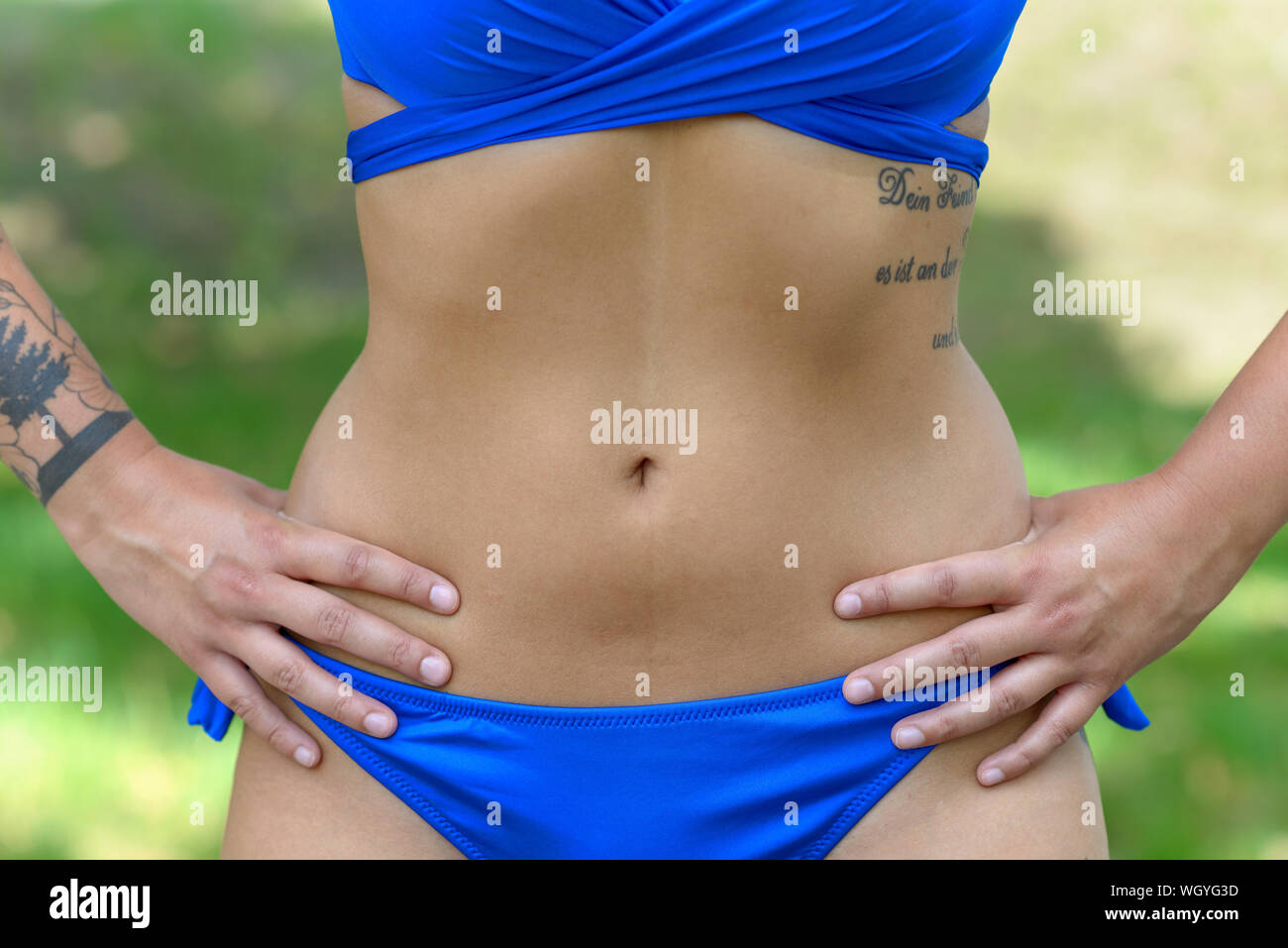 Sun beach bikini body woman with toned abs and slim legs tanning