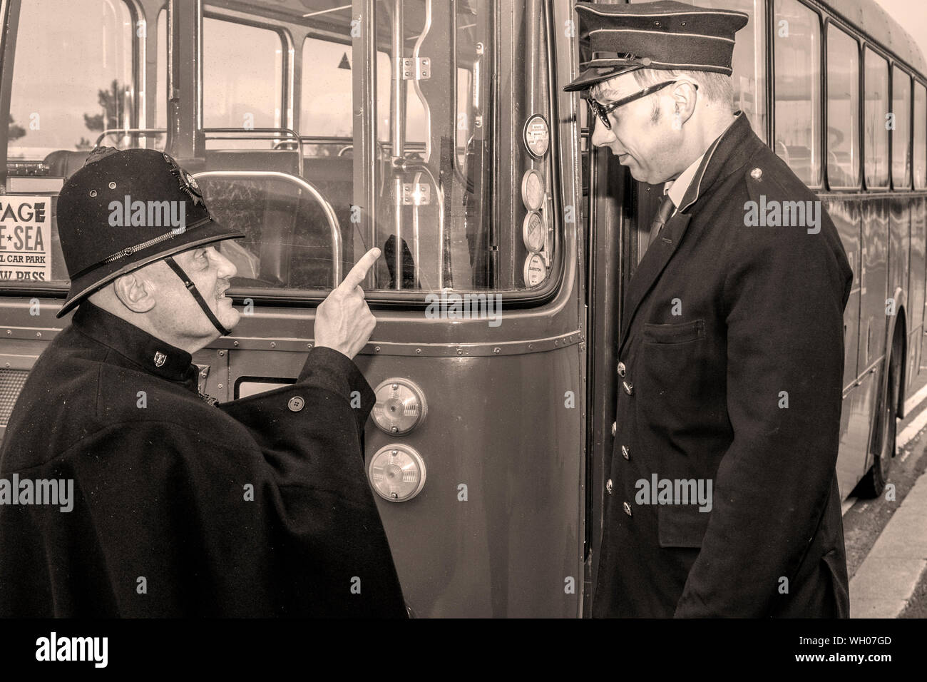 British Police constable admonishing bus driver; Morecambe historical seafront events; 1930s, 1940s,1950s, retro fashion festival Vintage by the sea, people in costume, reenactors in period costumes, authentic period clothing, wartime fancy dress, historical costumes, reenactment clothes, UK Stock Photo