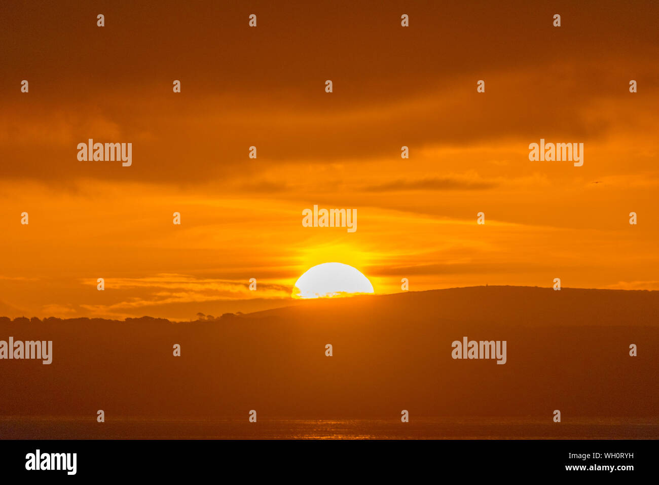 Newlyn, Cornwall, UK. 2nd September 2019. UK Weather. Clouds moved in at sunrise, bringing light showers, with the sun just managing to break through a gap in the approaching clouds.  Credit Simon Maycock / Alamy Live News. Stock Photo