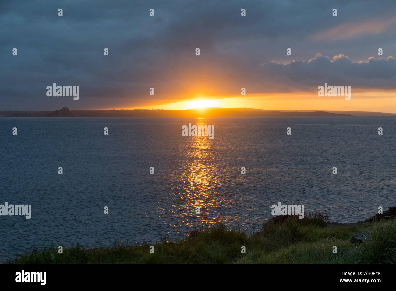 Newlyn, Cornwall, UK. 2nd September 2019. UK Weather. Clouds moved in at sunrise, bringing light showers, with the sun just managing to break through a gap in the approaching clouds.  Credit Simon Maycock / Alamy Live News. Stock Photo