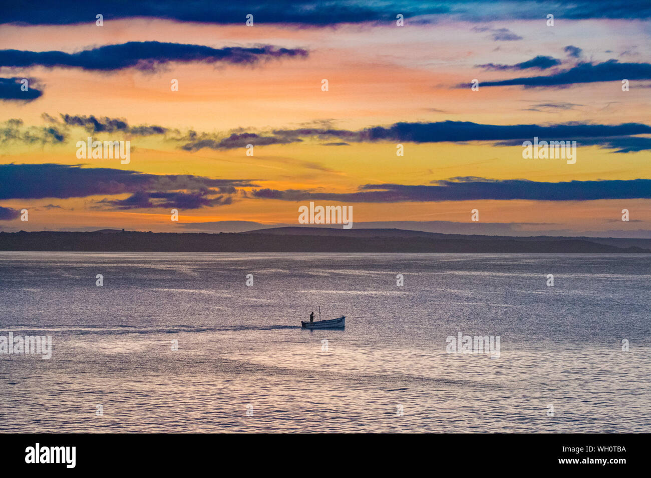 Newlyn, Cornwall, UK. 2nd September 2019. UK Weather. Clouds moved in at sunrise, bringing light showers, with the sun just managing to break through a gap in the approaching clouds.  Credit Simon Maycock / Alamy Live News. Stock Photo