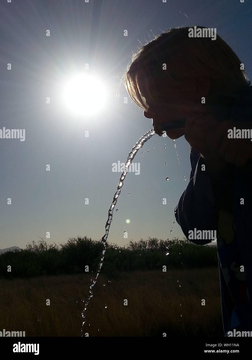 Boy Drinking Water From Hose On Sunny Day Stock Photo Alamy