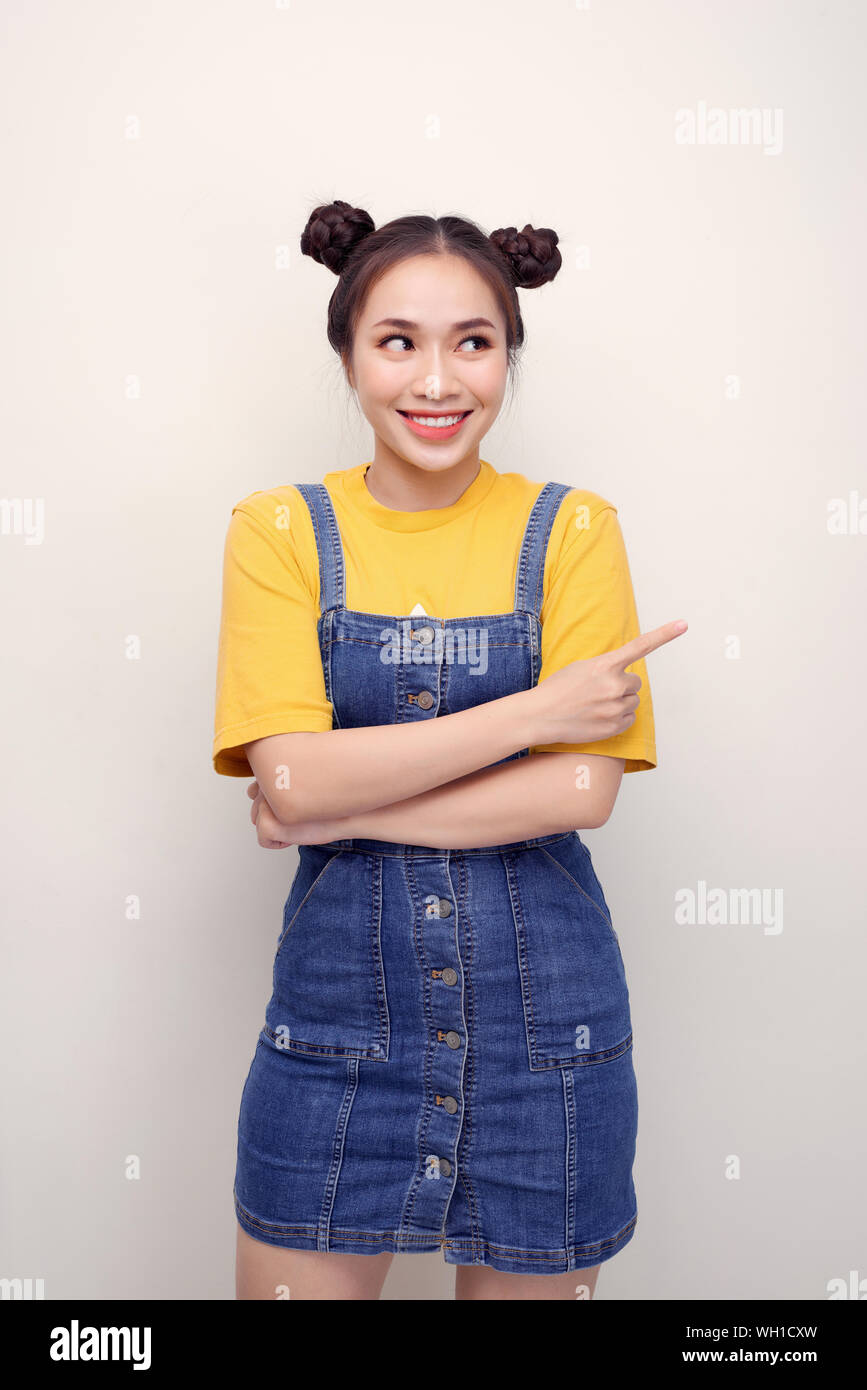 Close up photo beautiful amazing she her lady buns show indicate direct index finger empty space new product wear casual t-shirt jeans denim overalls Stock Photo