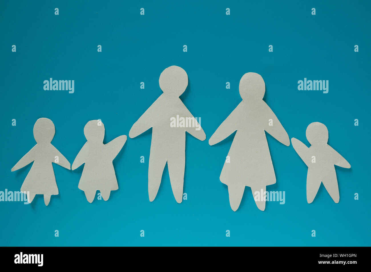 Paper family on blue background with copy space Stock Photo - Alamy