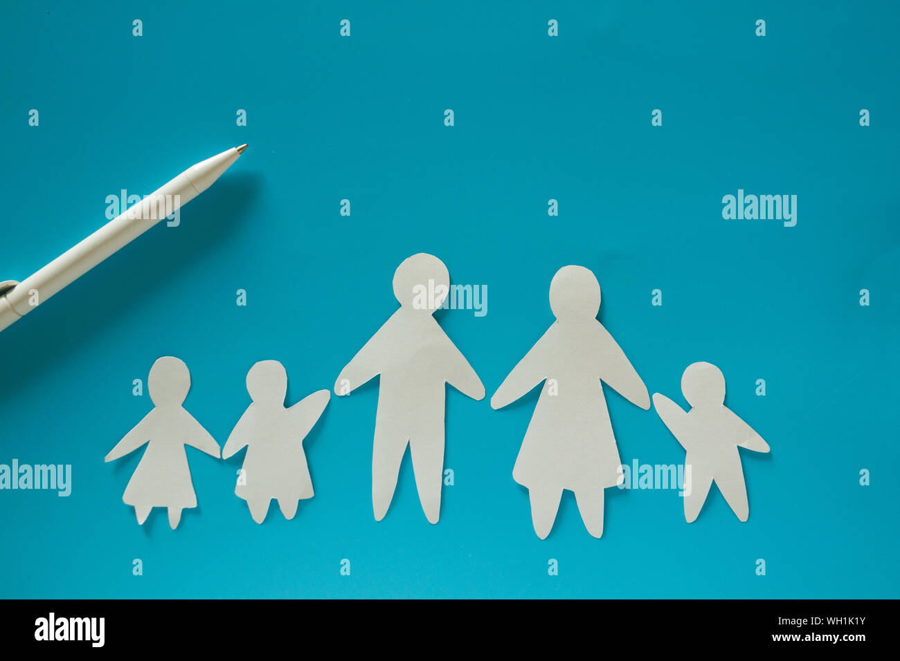 Paper family on blue background with copy space Stock Photo - Alamy