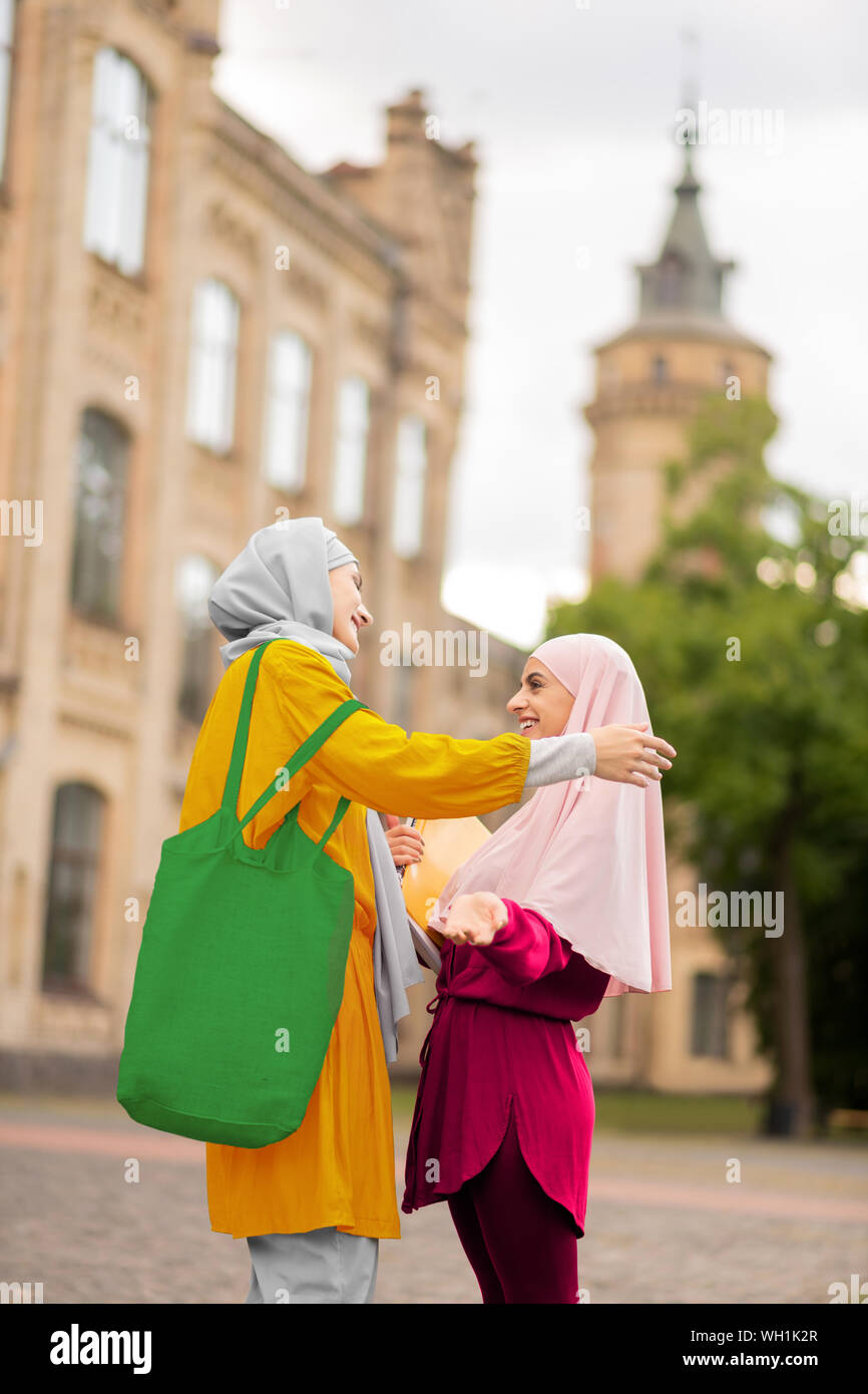 Muslim student wearing pink hijab meeting best friend Stock Photo - Alamy