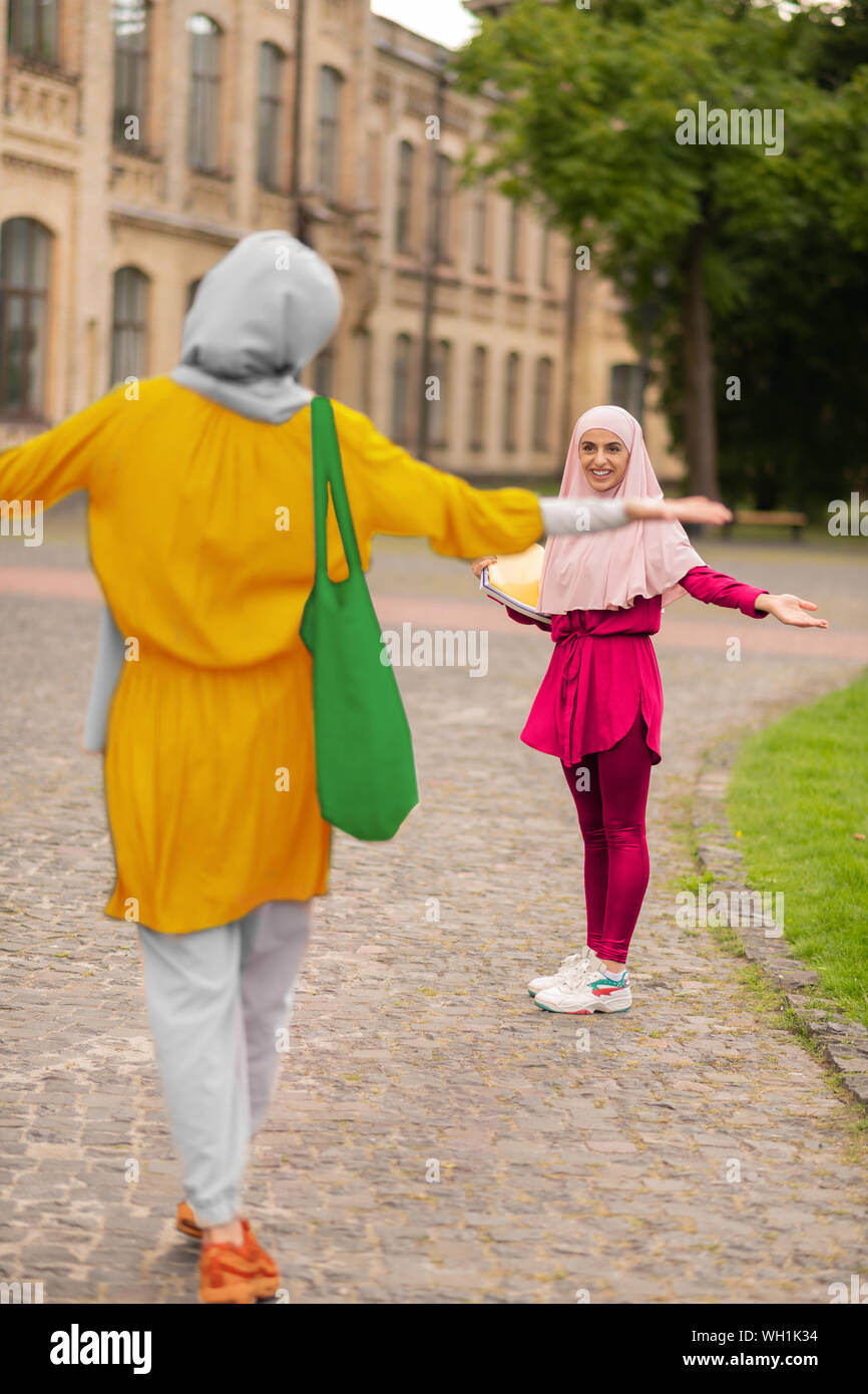 Two muslim students feeling happy while meeting near university Stock Photo