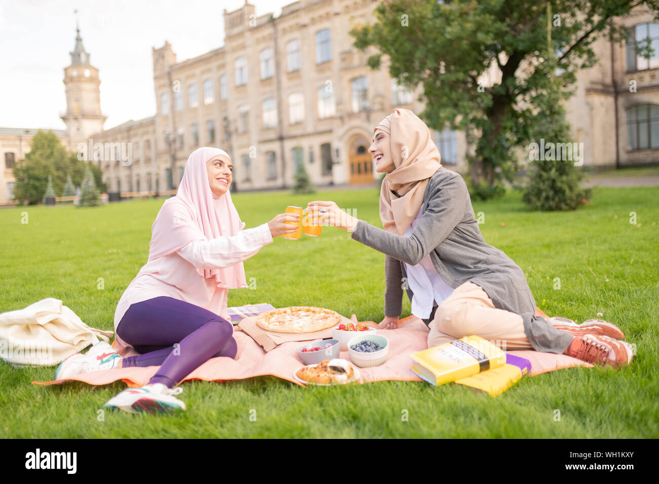 Muslim students having nice lunch break outside near university Stock Photo