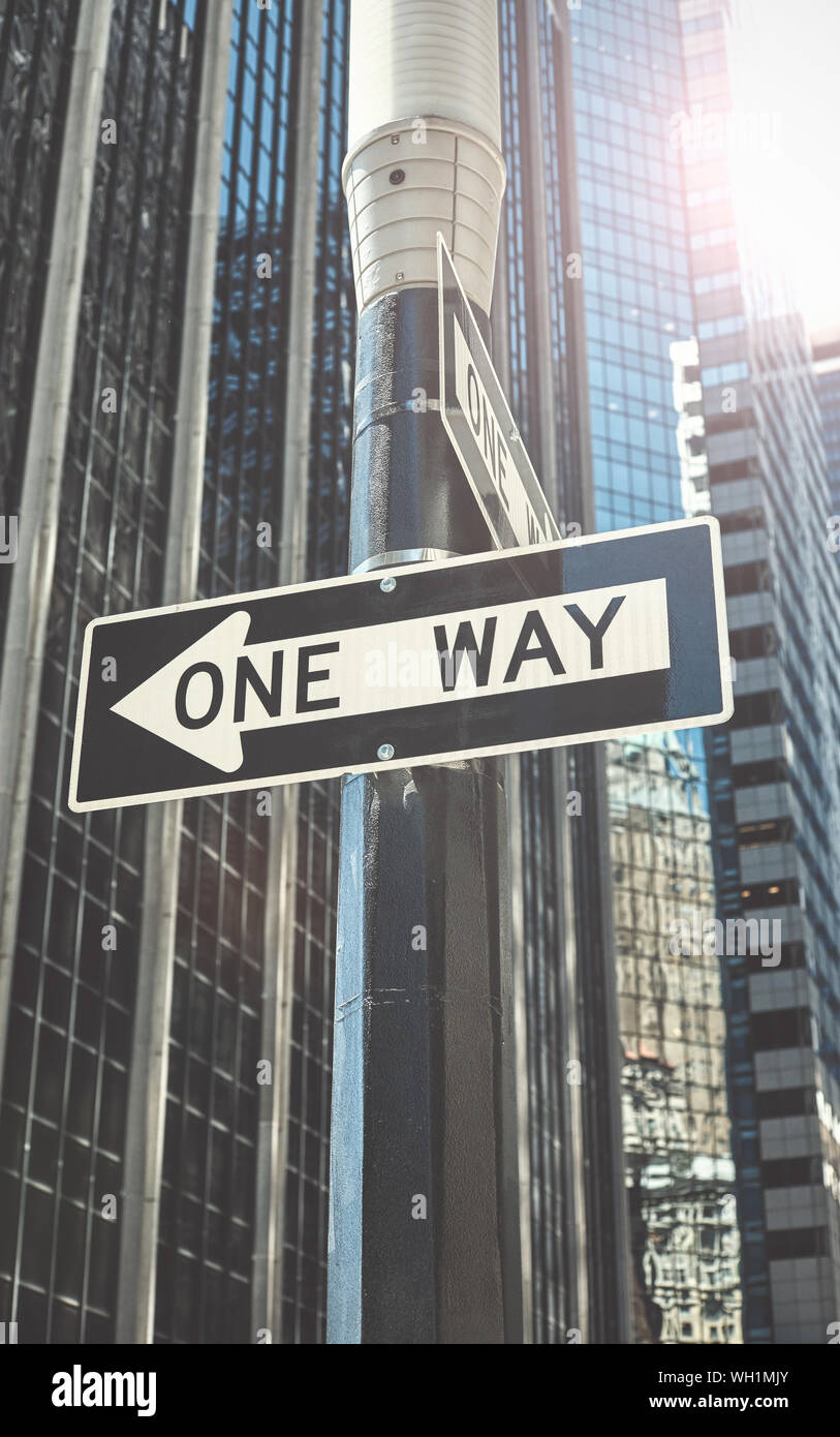 One way street sign against the sun in New York City, color toning ...