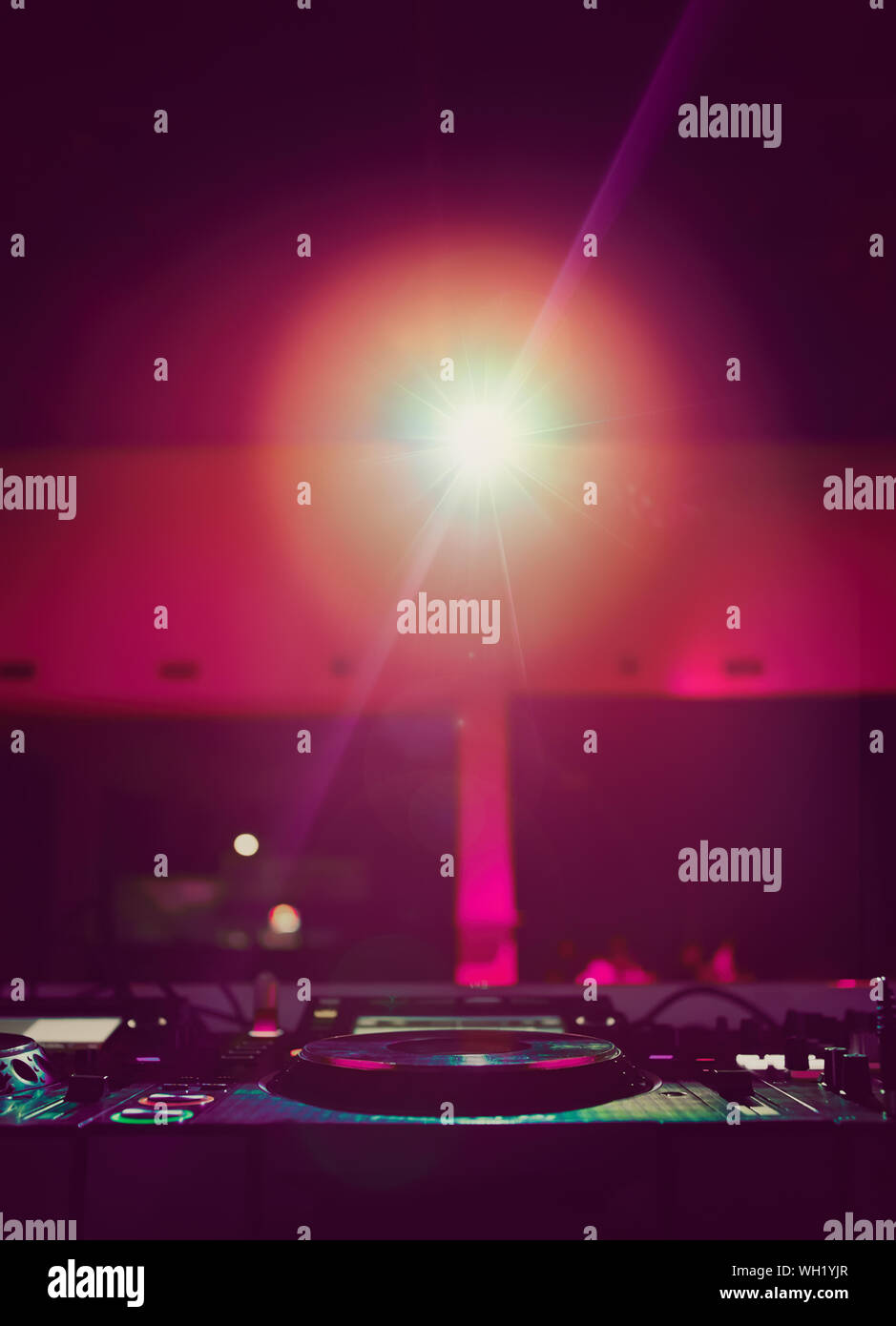 Concert dj setup with turntables and sound mixer in bright magenta