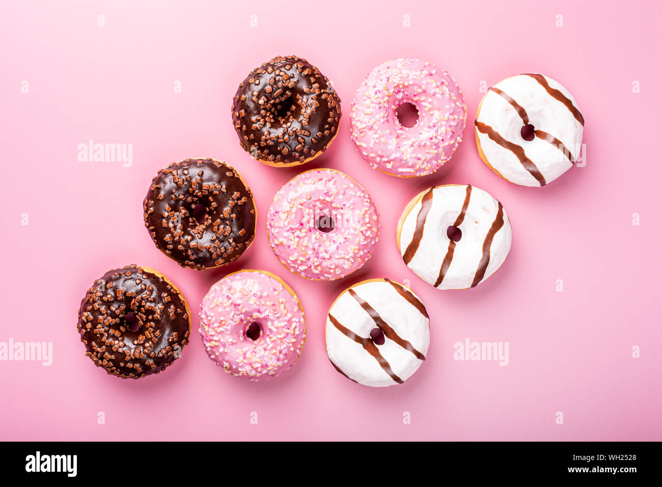Colorful donuts on rose background Stock Photo