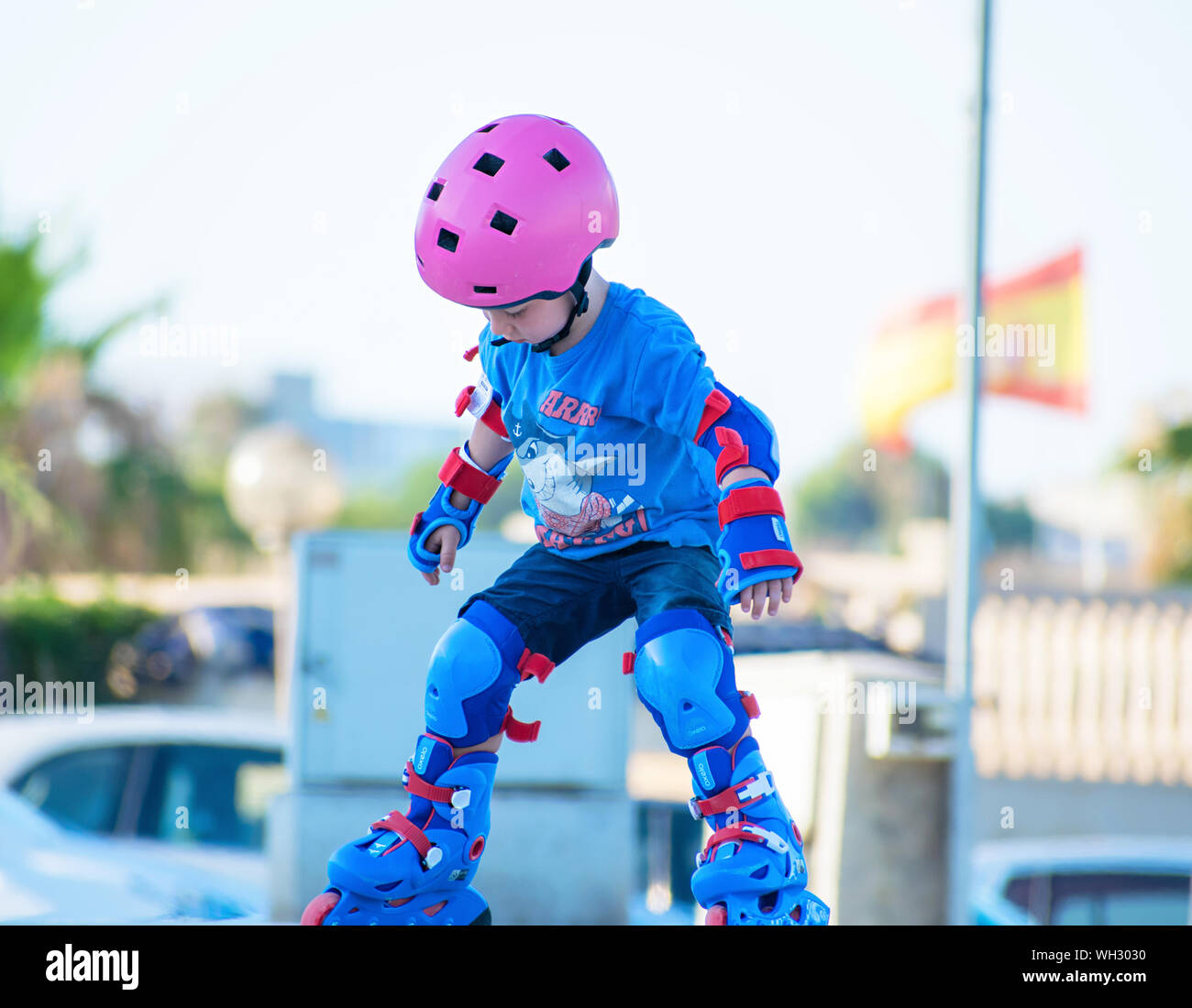 Murcia, Spain, July 17, 2019: adorable preschooler weepy as her rollerblades made her fall. On a city background. Initiation classes to rollerblading. Stock Photo