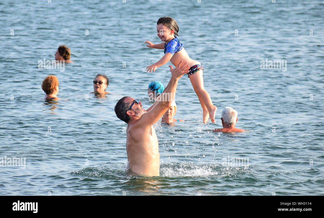 Murcia, Spain, July 20, 2019: Father throwing daughter in the beach during summertime.  Fatherhood on summer. Dad playing with daughter. Daddy love Stock Photo