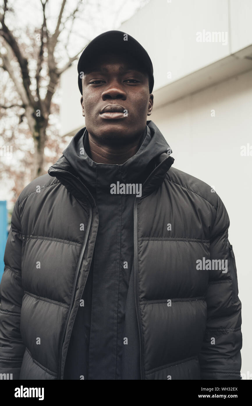 portrait of young african man standing in the street and looking camera ...