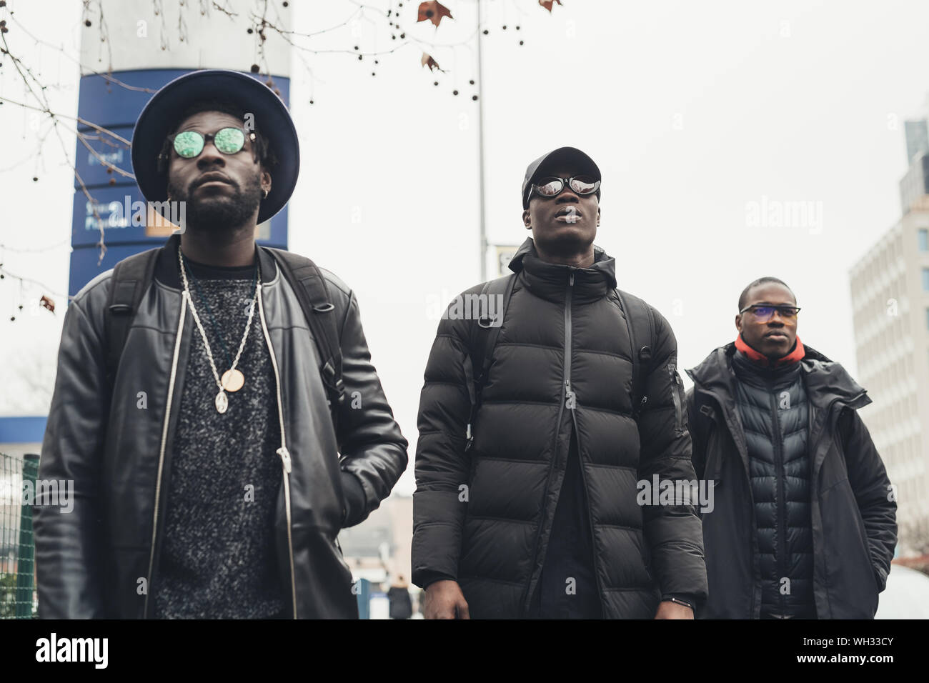 three young black men walking in the street and looking further - self confidence, youth, mobility Stock Photo