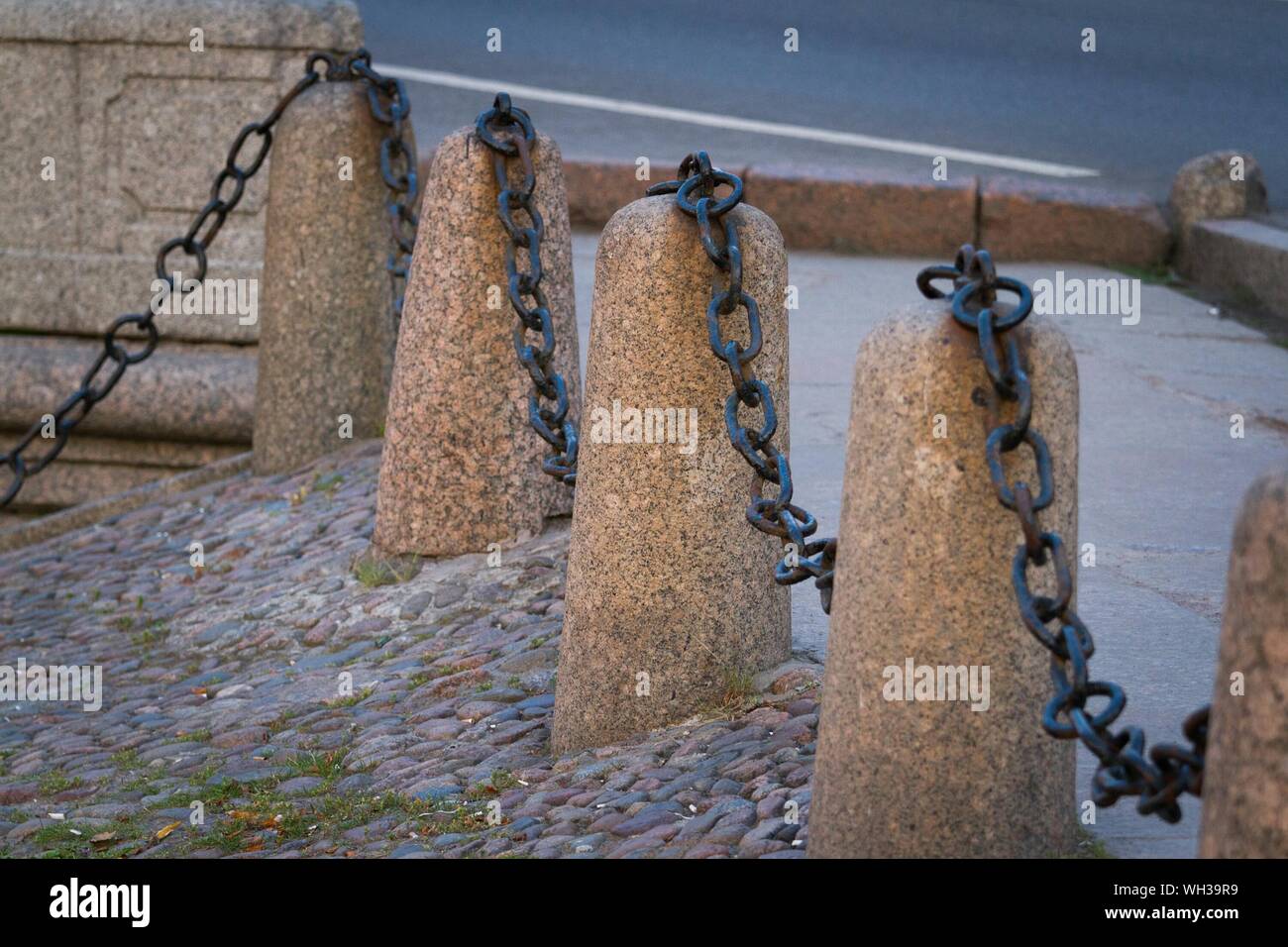 Metallic Chain On Stone Bollard Stock Photo - Alamy