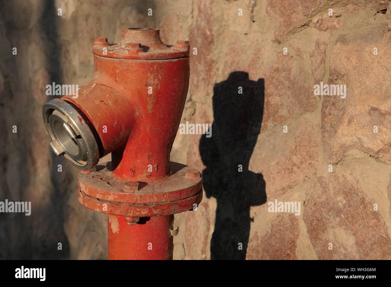 Broken Fire Hydrant Against Wall On Sunny Day Stock Photo Alamy