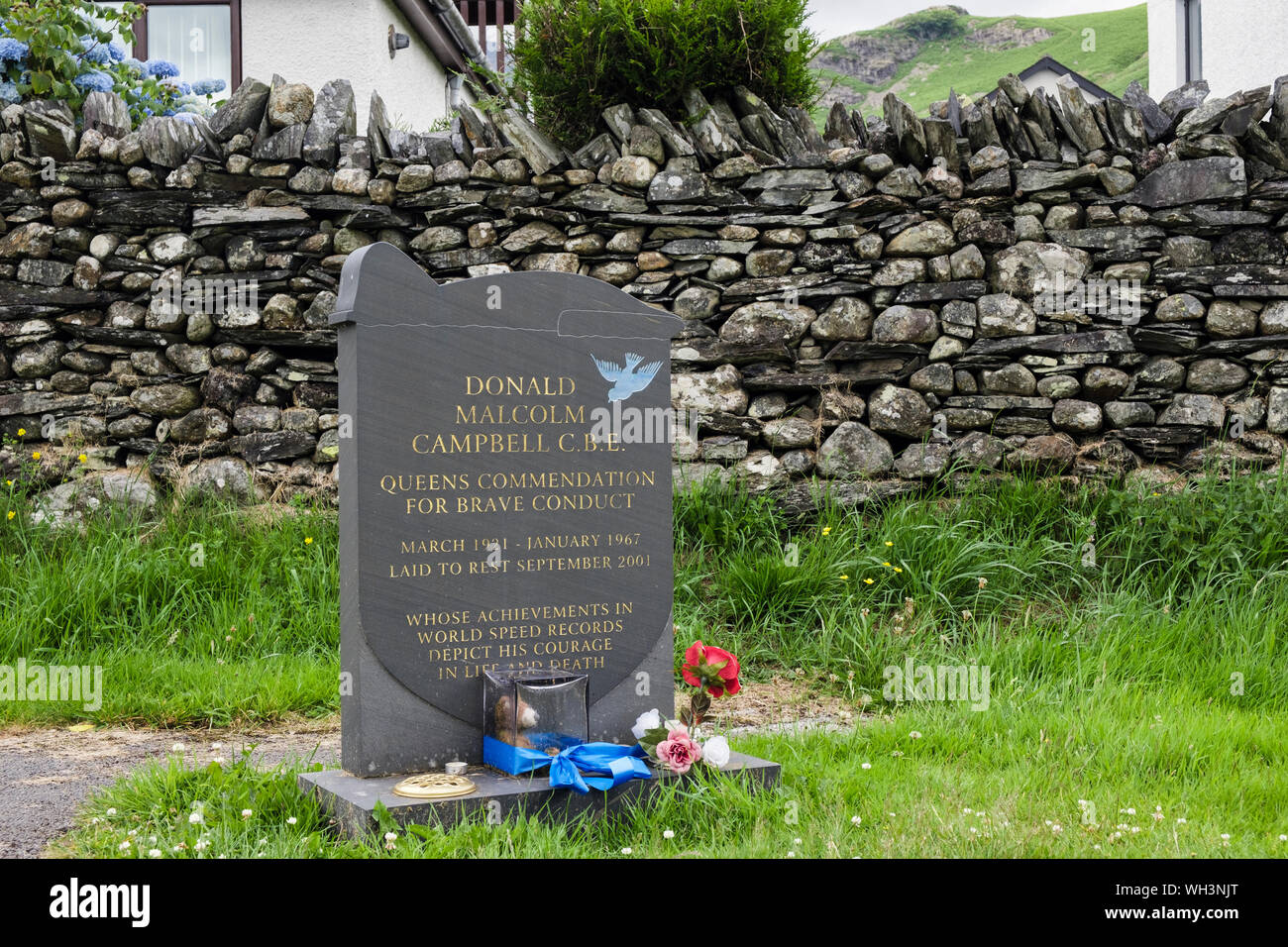Grave of Donald Malcolm Campbell C.B.E. slate headstone with engraved bluebird in the churchyard. Coniston, Cumbria, England, UK, Britain Stock Photo