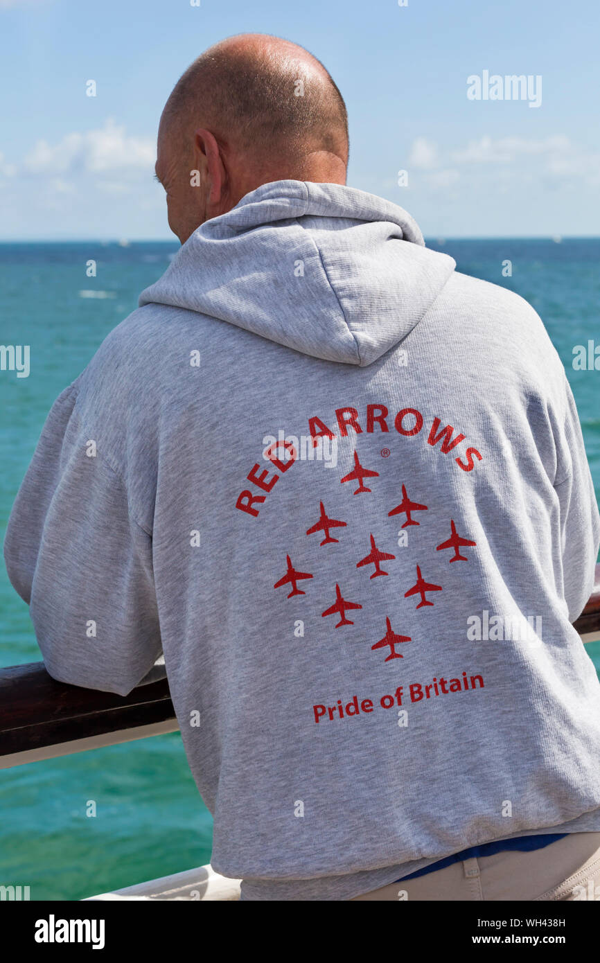 Man wearing hoodie with Red Arrows Pride of Britain on the back at Bournemouth Air Festival, Dorset UK in August Stock Photo