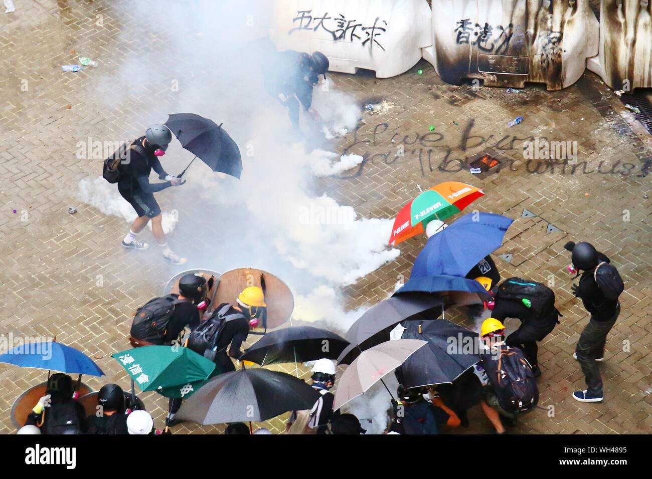 Hong Kong, China. 31st, August 2019. Riots escalates in different districts after the unauthorized peaceful rally. Here the protesters throw petrol bombs at the Central Government Office at Admiralty and the Police deploy tear gas. Stock Photo