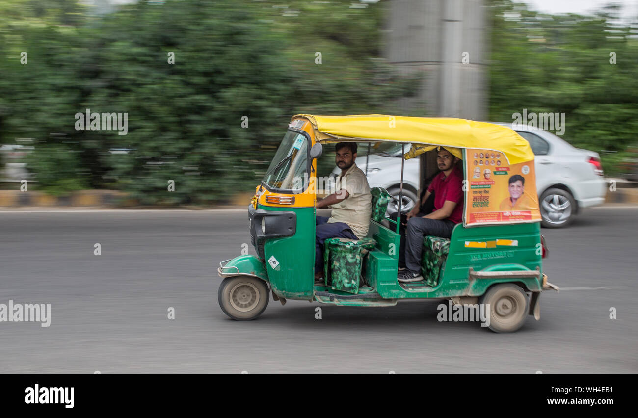 A rickshaw speeding down a road in Gurgaon, India. Stock Photo
