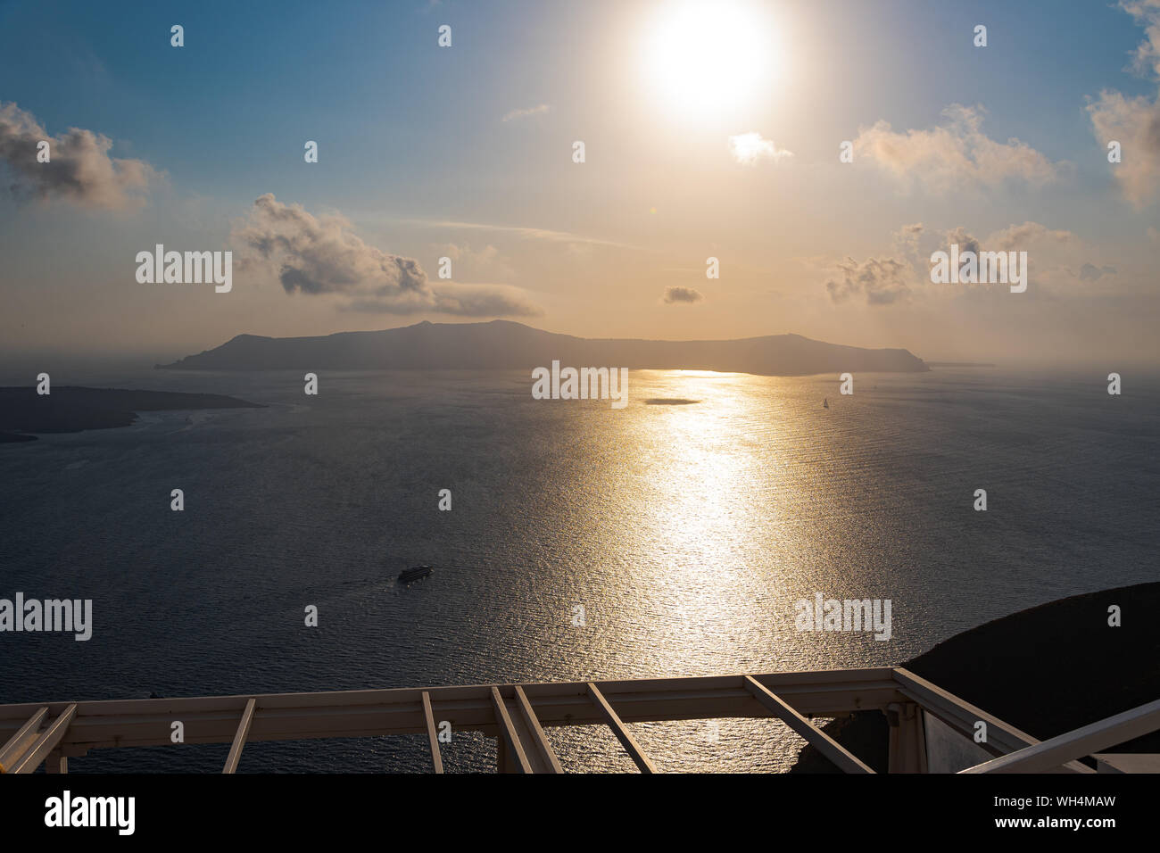 The sun setting over the islands of Santorini in the Aegean sea Stock Photo