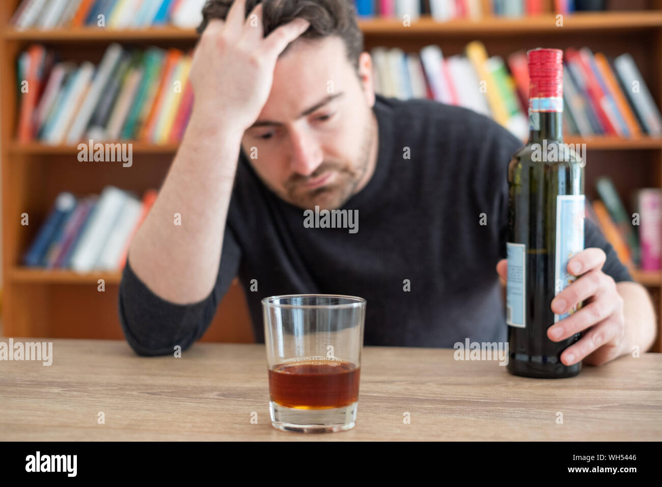 Depressed man drinking hard liquor at home Stock Photo