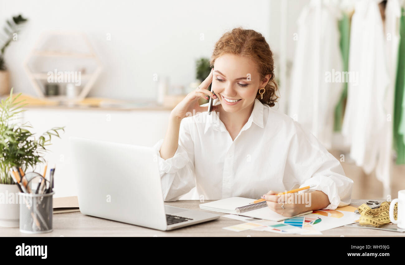 Fashion designer ordering fabric, talking on phone Stock Photo
