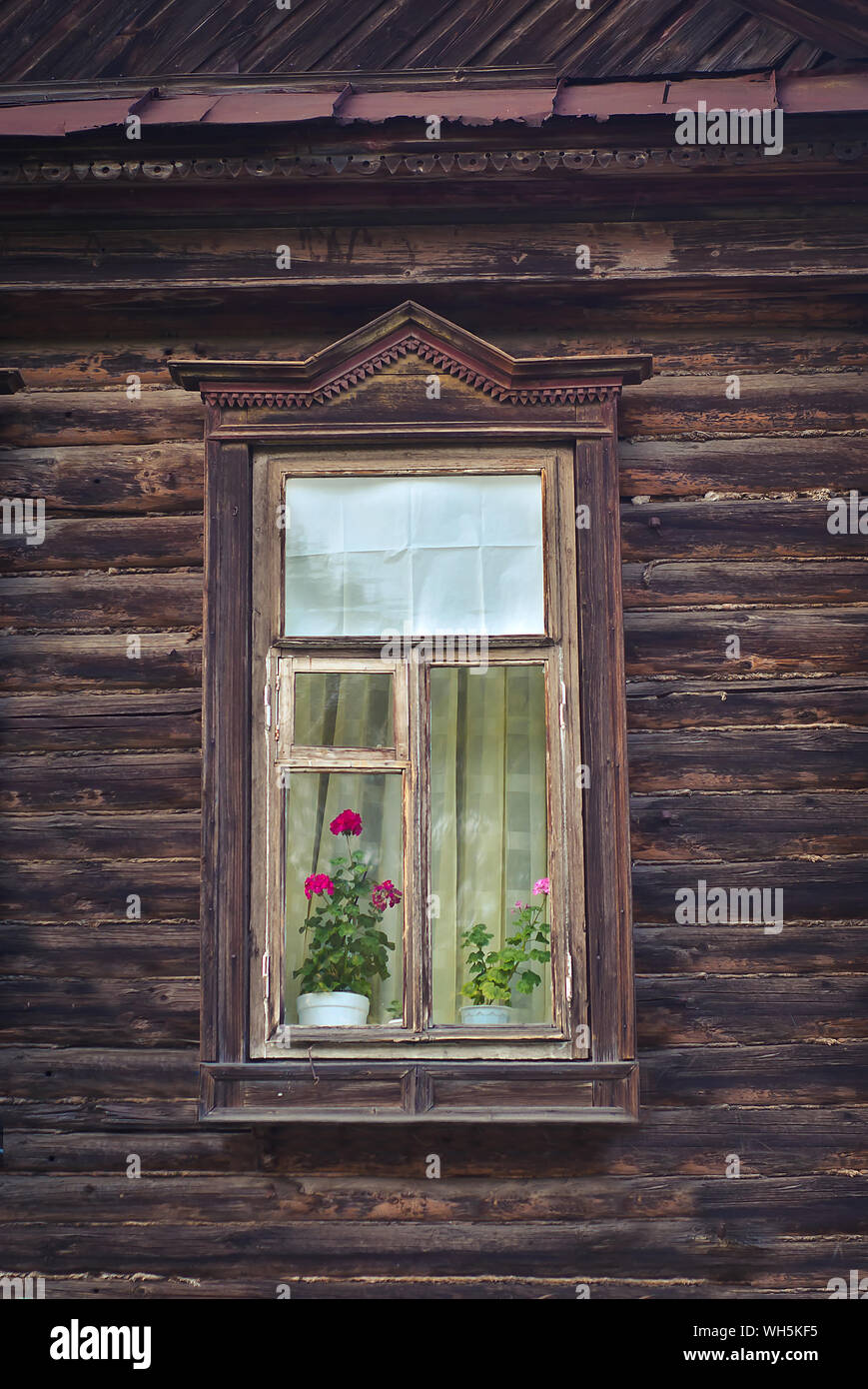 Window with flower in an old wooden house in Russia Stock Photo