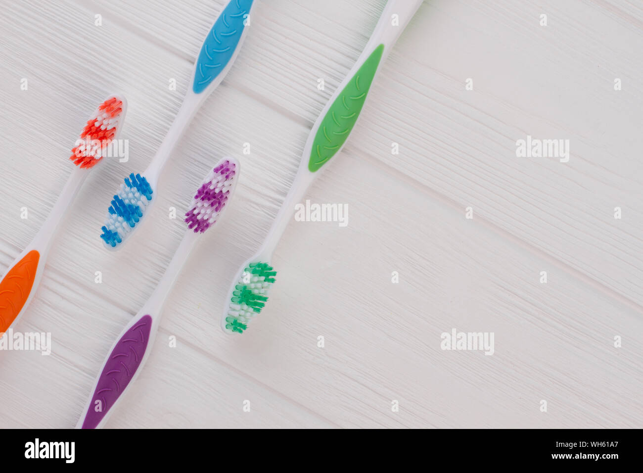 Group of four soft toothbrushes on wooden background. Stock Photo