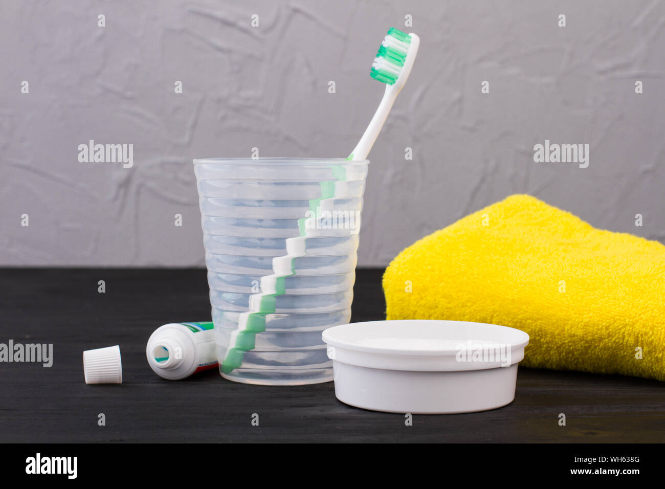 Toothbrush in glass, toothpaste and towel in bathroom Stock Photo Alamy