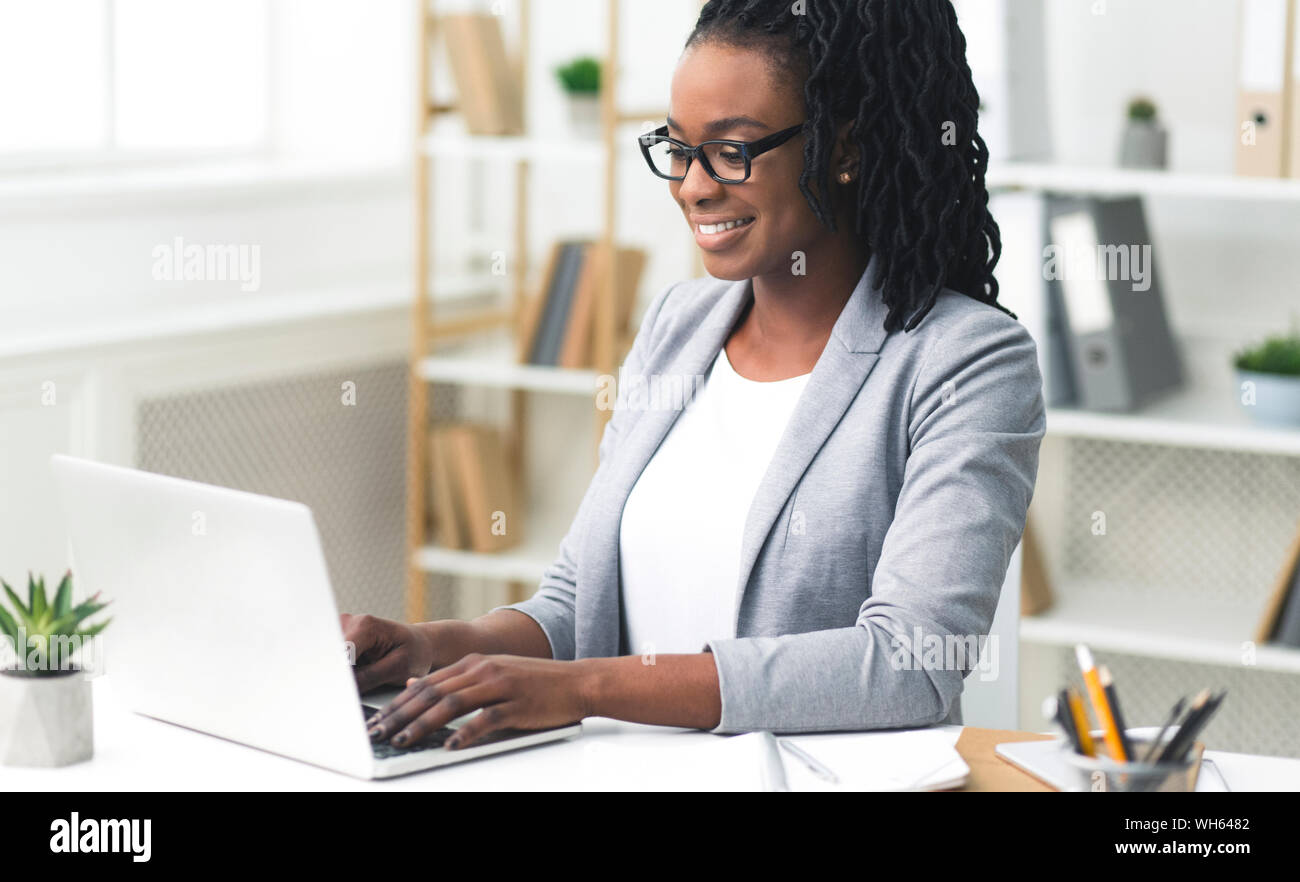 African American Office Girl Typing Something On Laptop At Work Stock ...