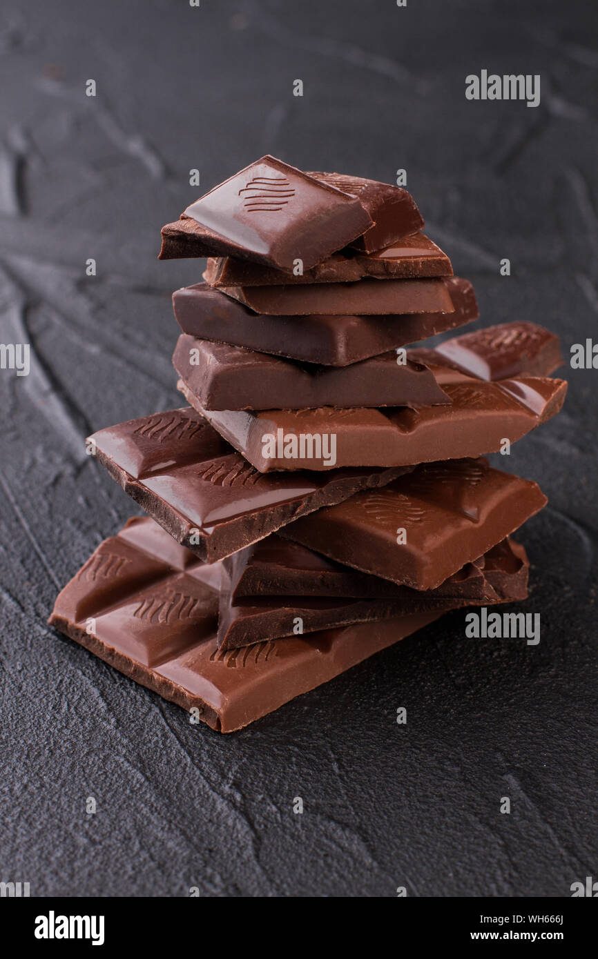 Dark milk chocolate bars stack on black background Stock Photo - Alamy