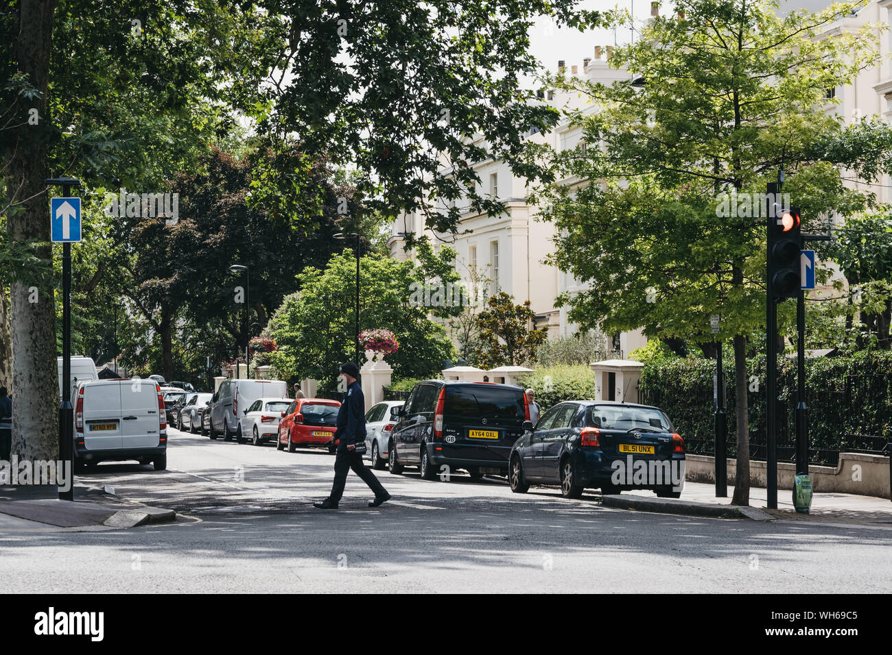 London, UK - July 18, 2019: Parking warden crossing the road in Marylebone, a chic residential area of London famous for Baker Street and Madame Tussa Stock Photo
