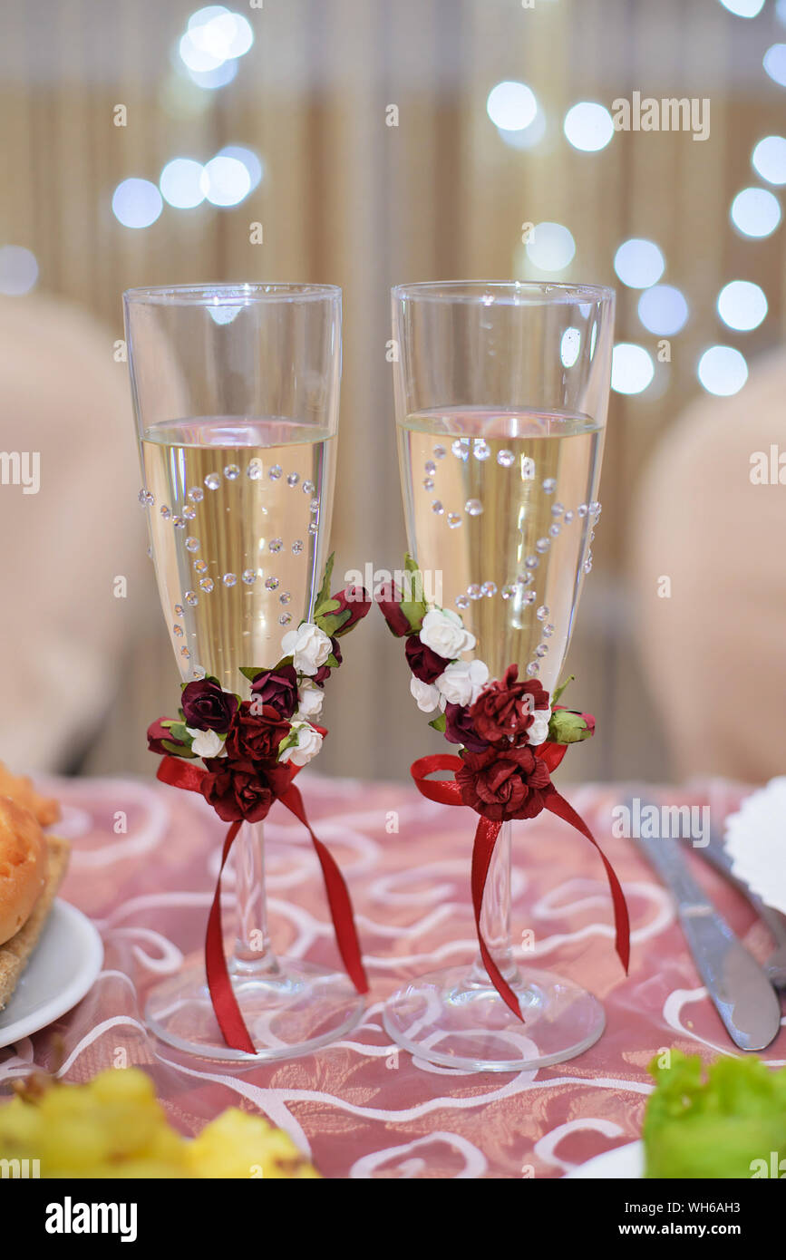 Decorated wedding glasses with champagne on a festive table Stock Photo