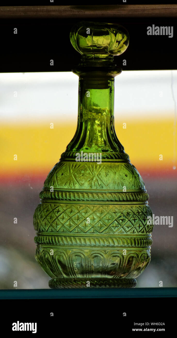 Close-up Of Antique Green Glass Bottle On Shelf At Store Stock Photo