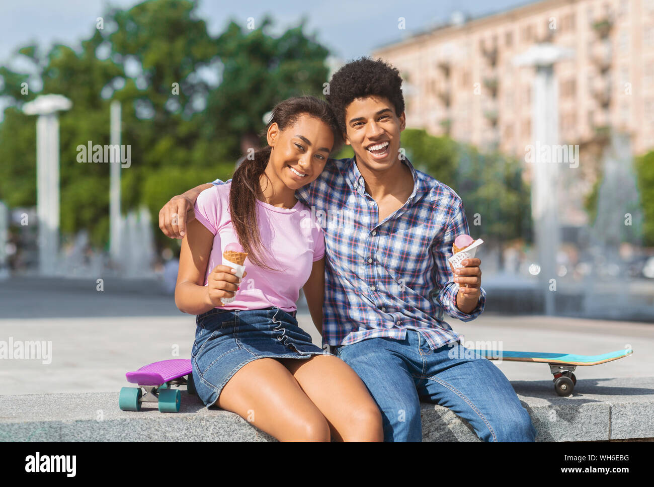 Cheerful teenagers having date in the city eating ice cream Stock Photo