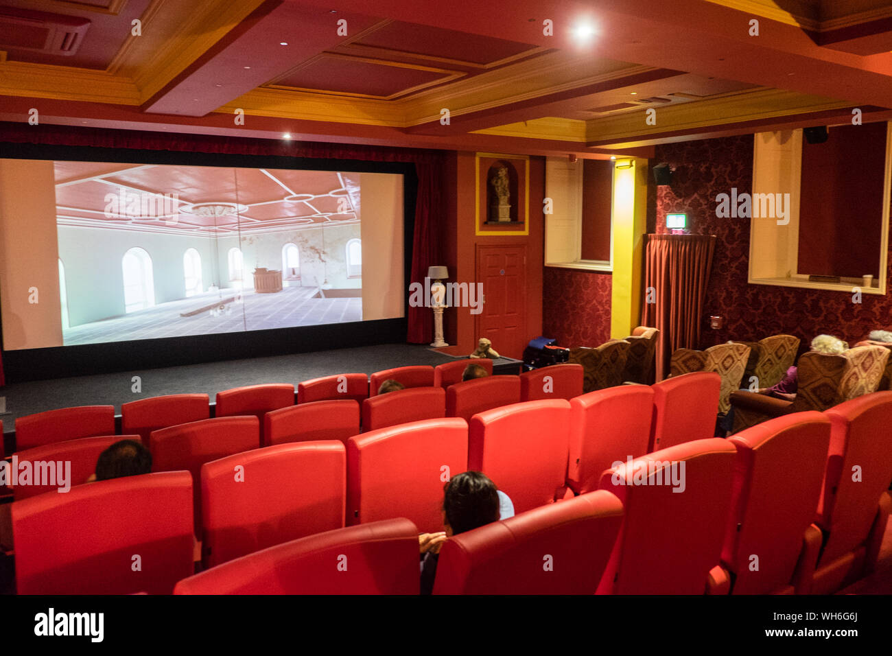 Libanus 1877,boutique,cinema,with,red,leather,seats,armchairs,with,cushions and blankets.Small,renovated,chapel,in,seaside,village,of,Borth,Wales,UK Stock Photo