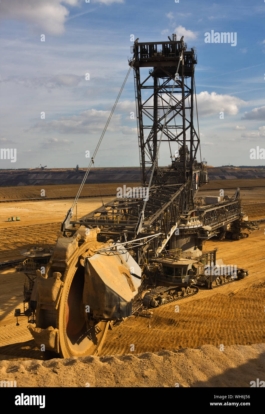 Giant bucket wheel excavator taking away the layers of ground before digging the brown coal. Stock Photo