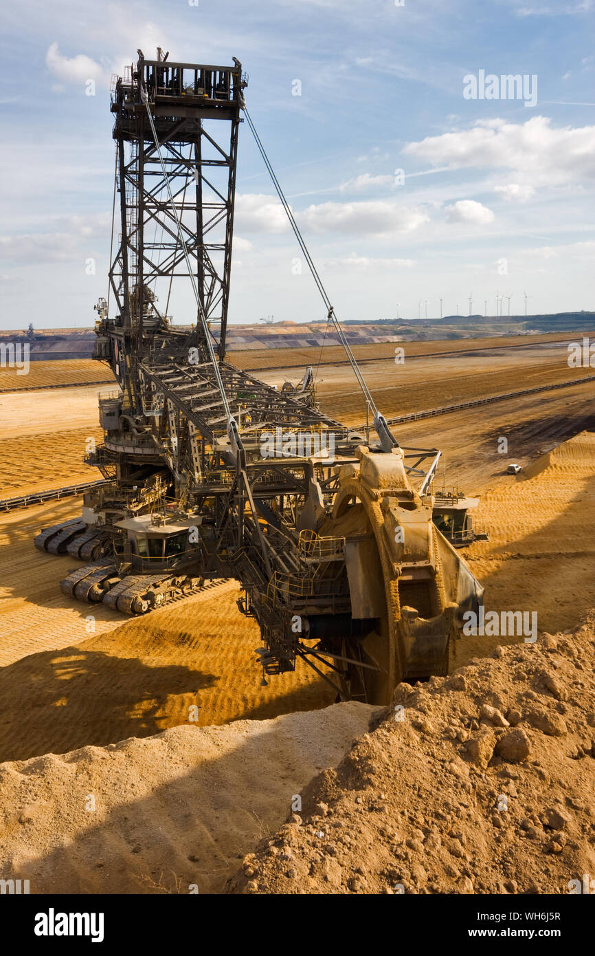 Giant bucket wheel excavator taking away the layers of ground before digging the brown coal. Stock Photo