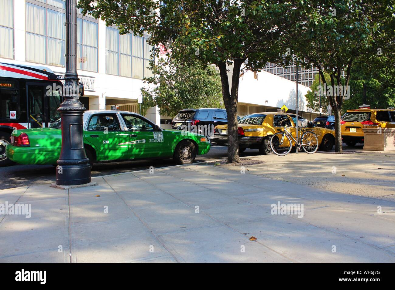 Newark, New Jersey - August 15th 2019: A queue of taxis line up along the busy, tree-lined, Market Street, just outside Penn Station, in Newark NJ. Stock Photo